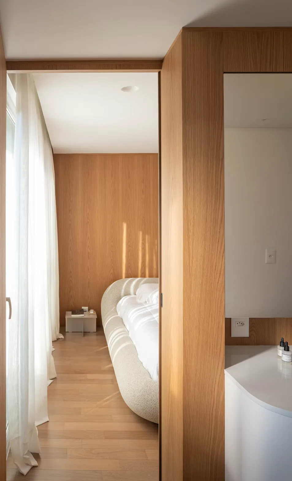 Warm modern bedroom framed by a wooden doorway.