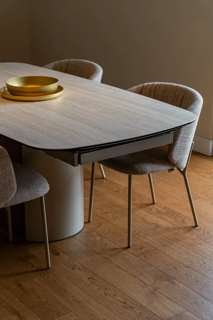 Composed modern dining room with warm wood and architectural depth.