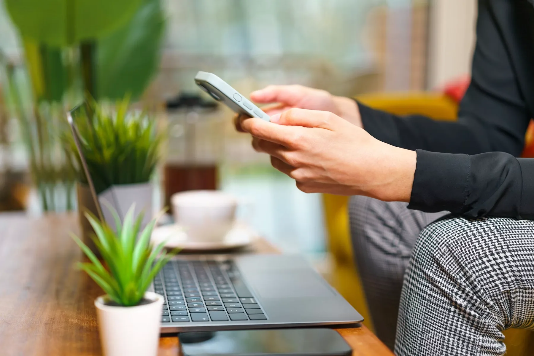 Person sitting on a sofa using a phone in a calm apartment.