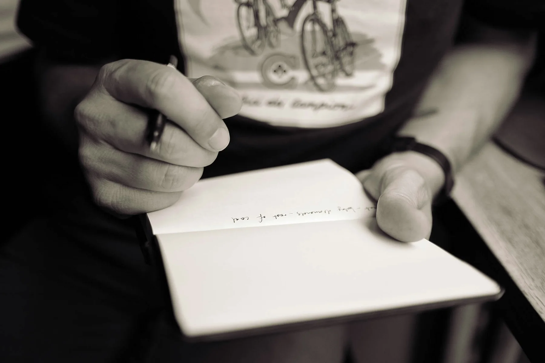 Close view of a person writing in a notebook.
